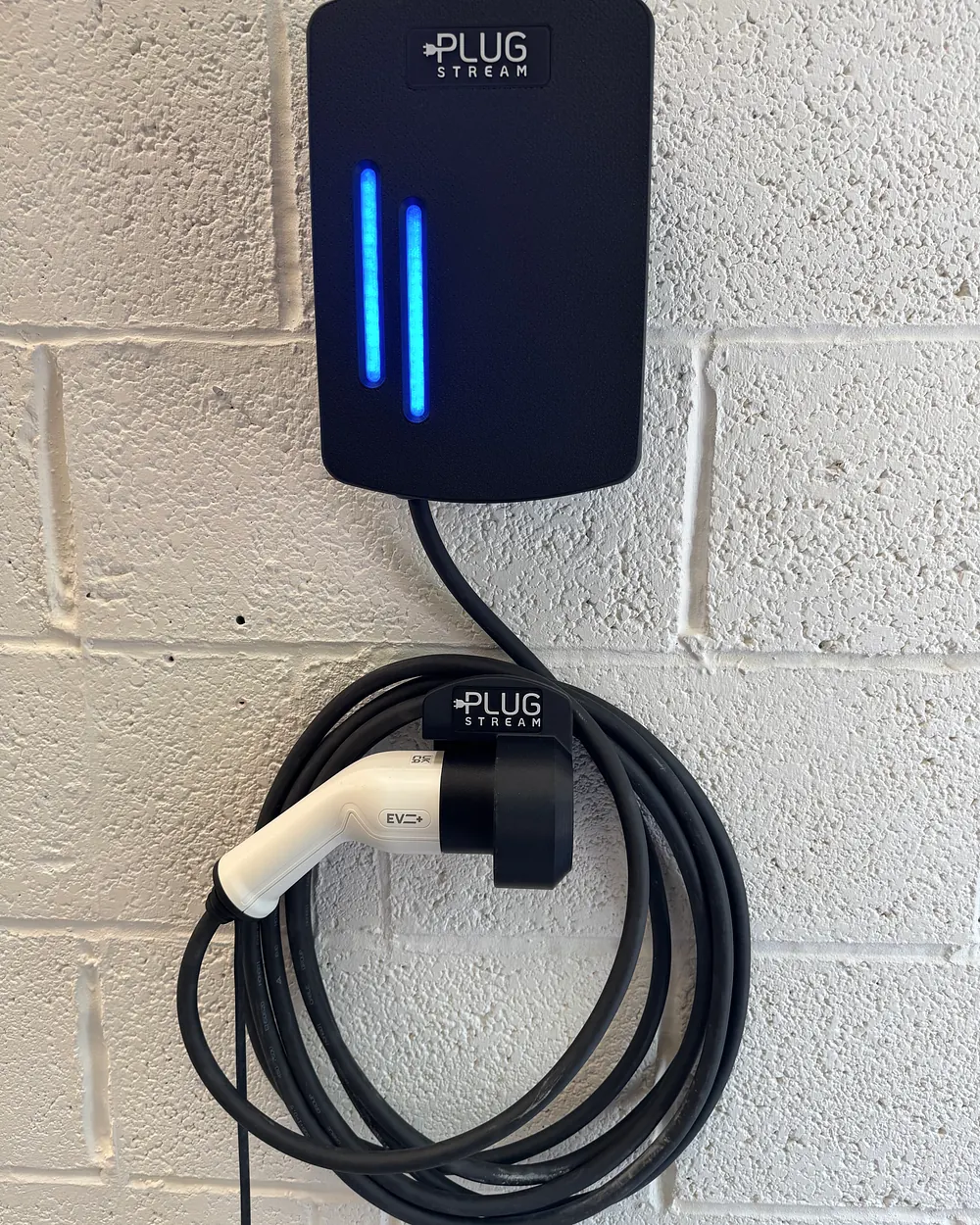 PlugStream Dock installed below a PlugStream charger with a cable loop