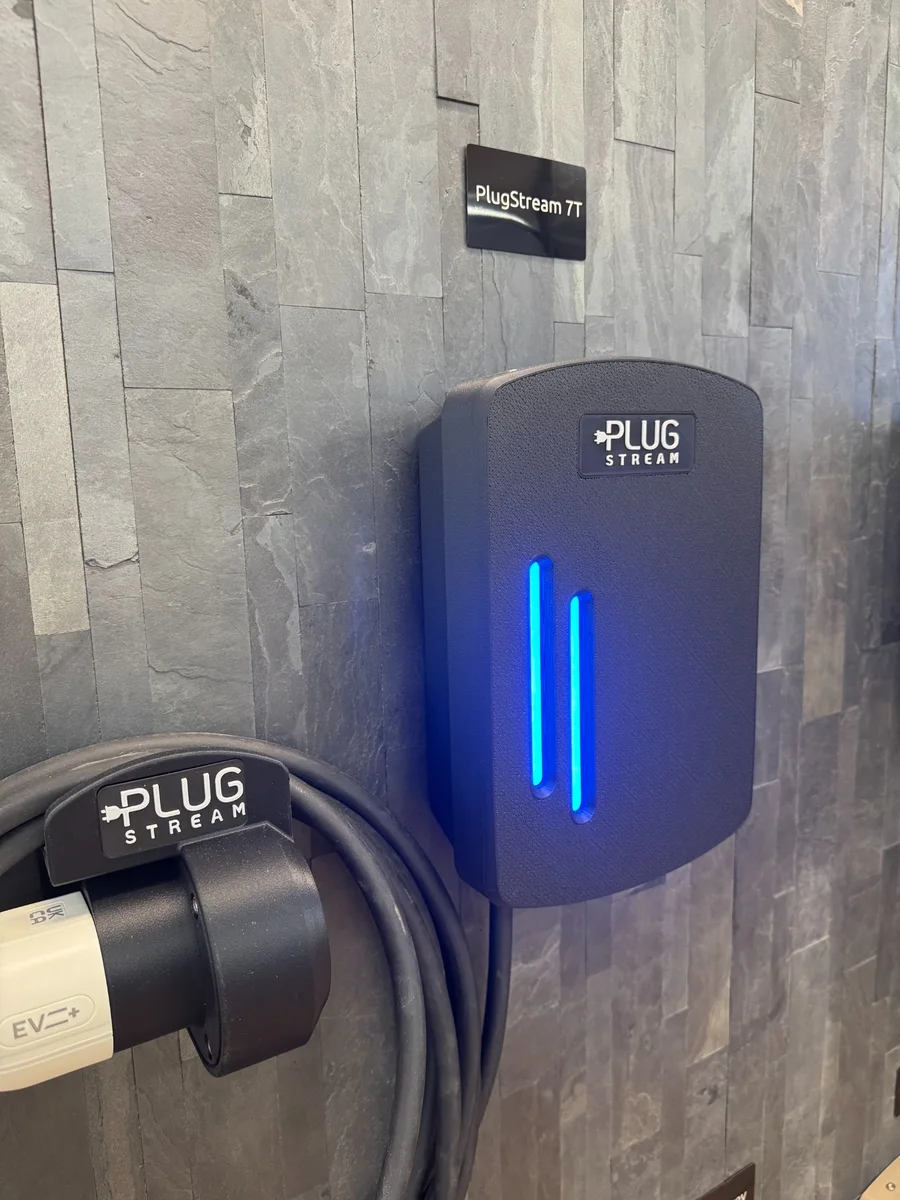 PlugStream 7T with blue LED illumination beside its cable dock and coiled charging cable