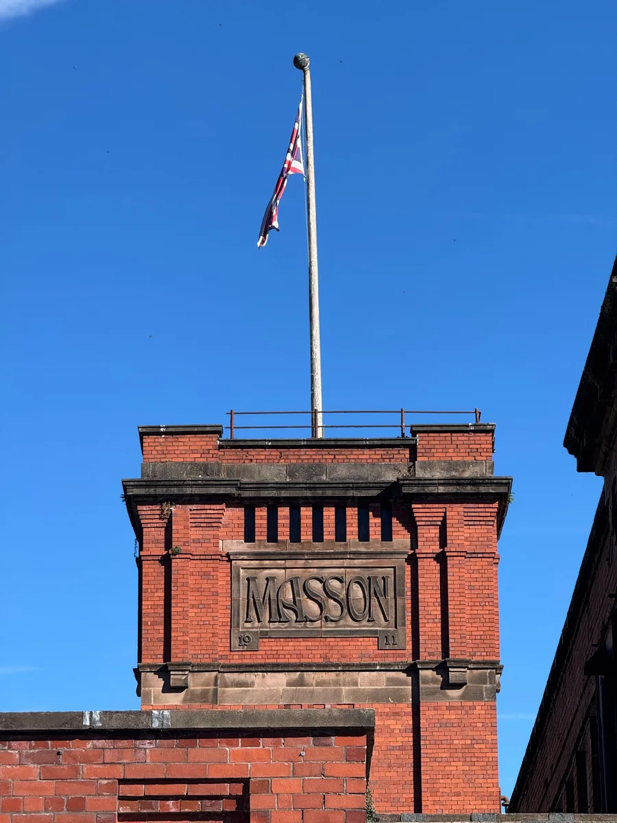 Red brick Masson Mills exterior with the Masson name carved above the windows